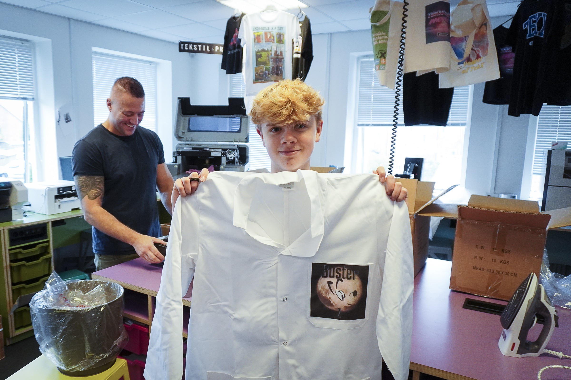 En elev viser sin færdig kittel med print